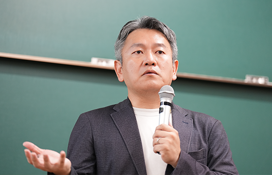 セミナーでマイクを持って講演する株式会社ソリデンテ代表取締役の大東正明